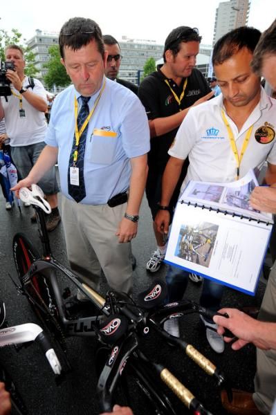 Race judges check riders' bike geometry