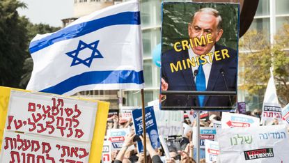 Israeli protesters take to the streets after police recommend indicting Netanyahu