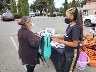 woman flor martinez giving backpack to farm worker