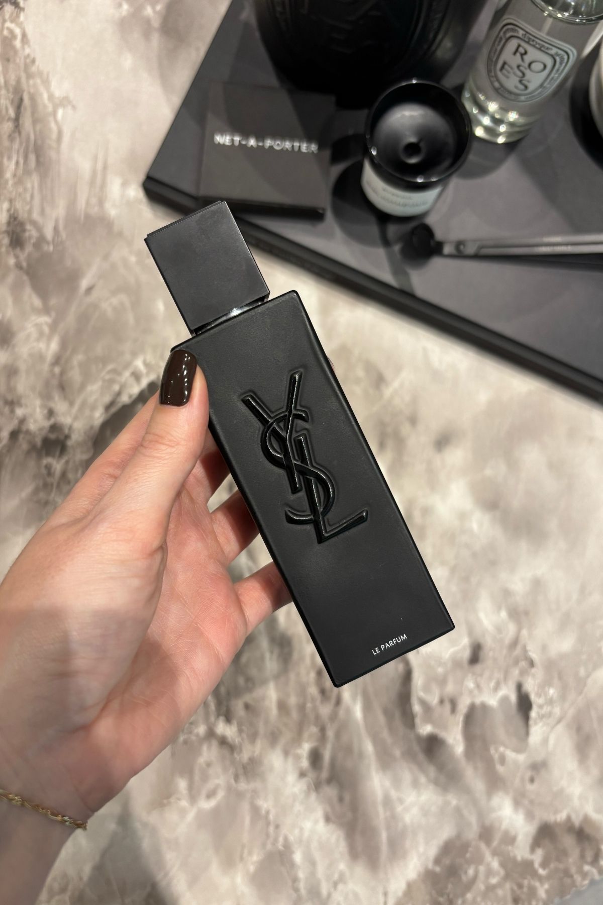 Deputy beauty editor Grace Lindsay holding a bottle of YSL Myslf