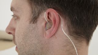 Close-up of an in-ear monitor positioned in a man's ear
