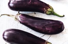 Miniature aubergines being cut and salted before cooking