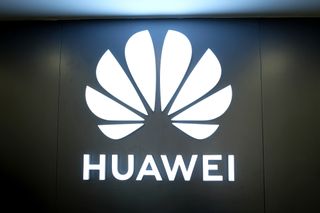 The Huawei logo glowing in a darkened room