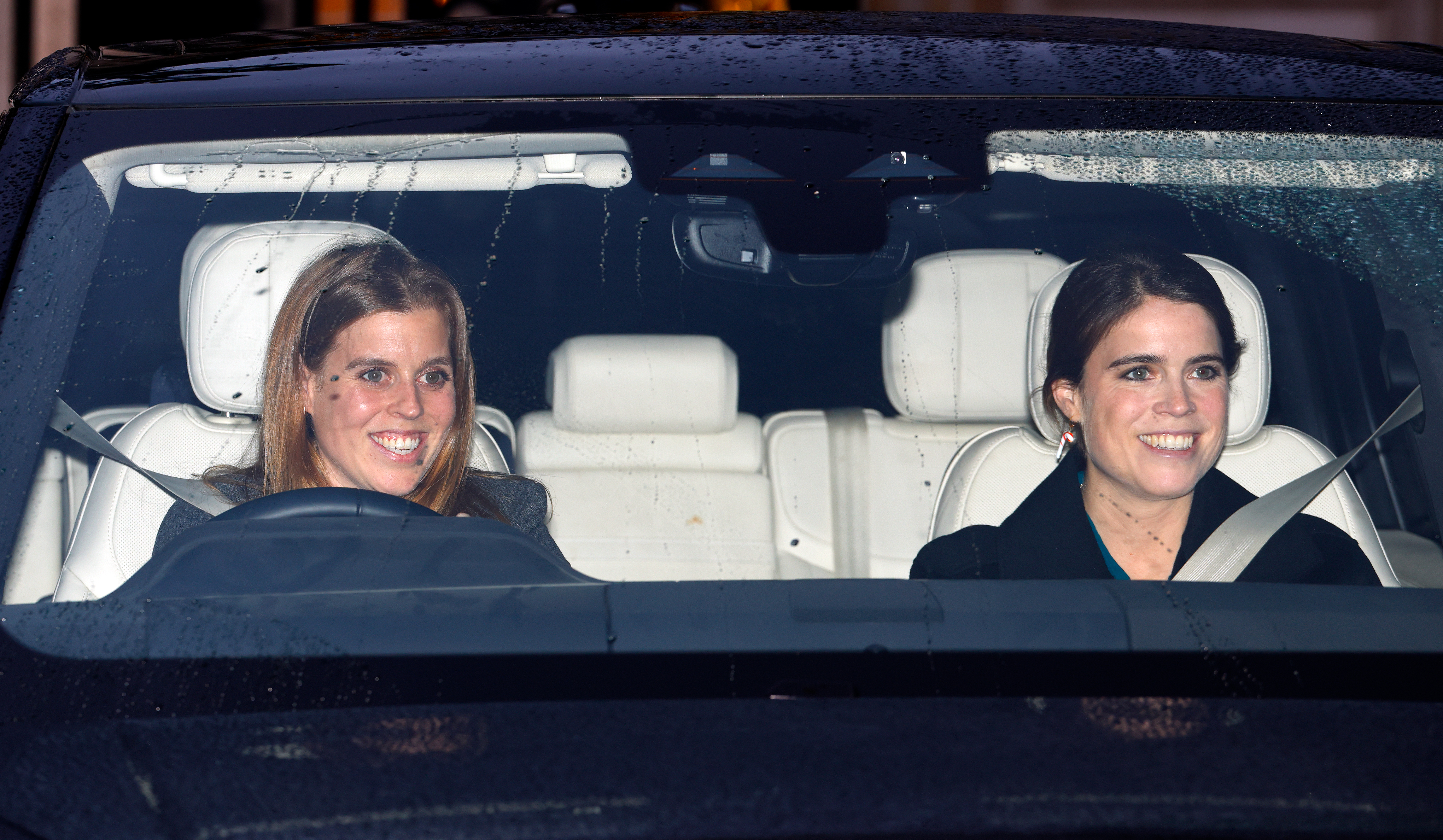 Princess Eugenie and Princess Beatrice riding in a car smiling