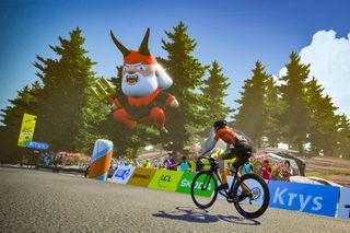 In game screenshot of a CCC rider climbing in Zwift past a recreation of Didi the devil