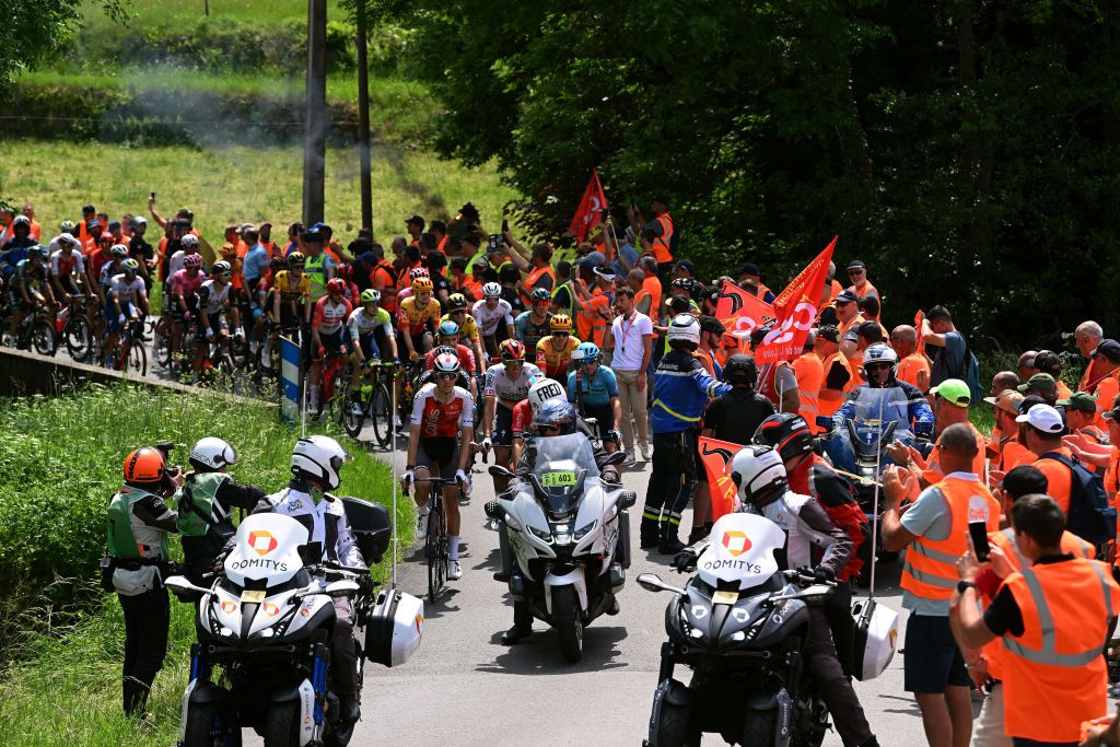 LE COTEAU FRANCE JUNE 06 The peloton resumes the route after being cut off by demonstrators in the village of Marols during the 75th Criterium du Dauphine 2023 Stage 3 a 1941km stage from MonistrolsurLoire to Le Coteau UCIWT on June 06 2023 in Le Coteau France Photo by Dario BelingheriGetty Images