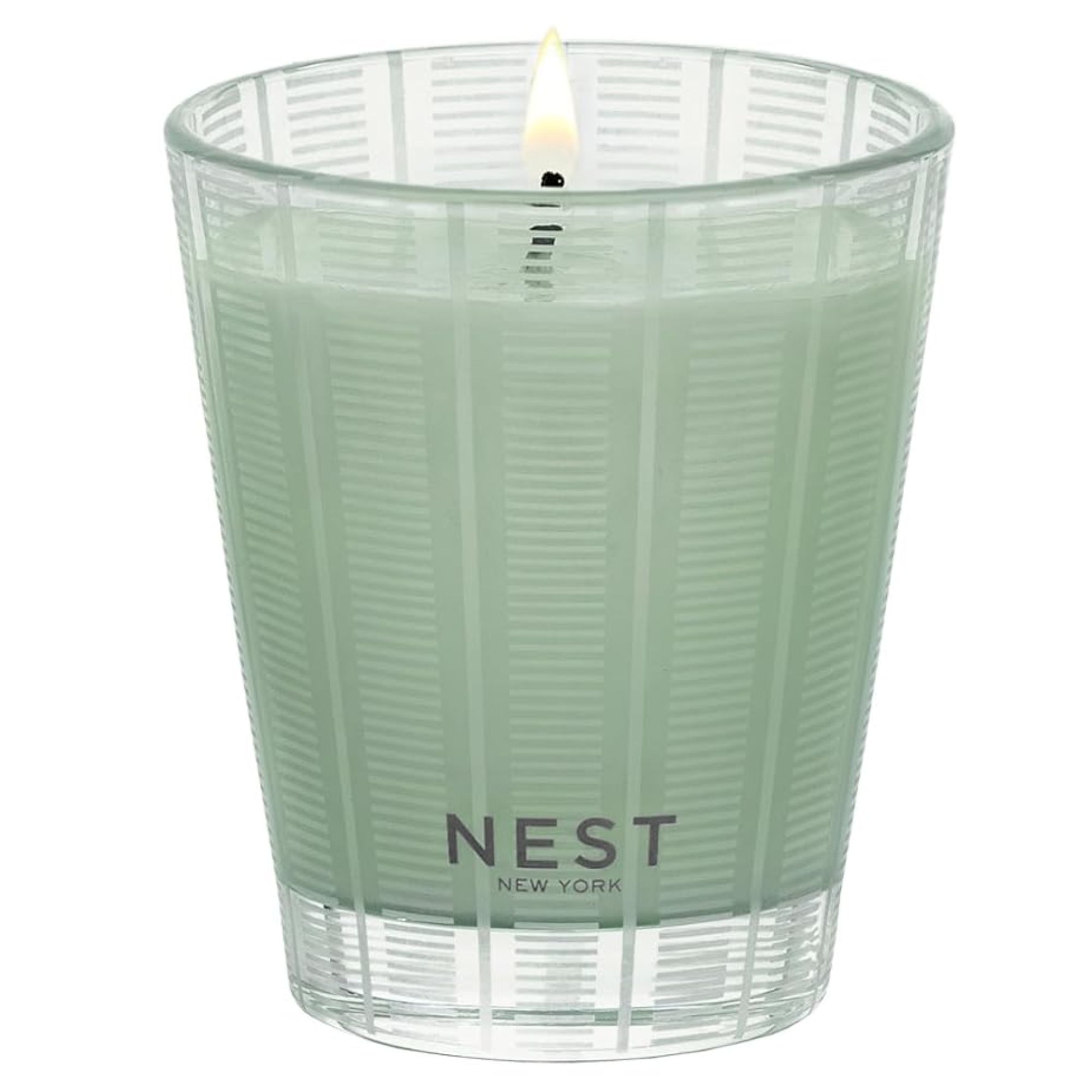 A lit NEST wild mint and eucalyptus candle with pale green wax