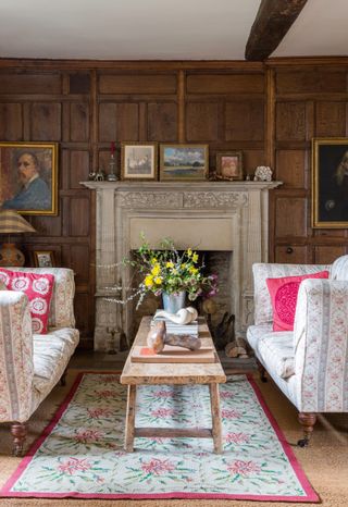 Floral Howard sofas and stone sculptures by fireplace in Jacobean manor house