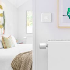 bedroom with smart thermostat on white wall