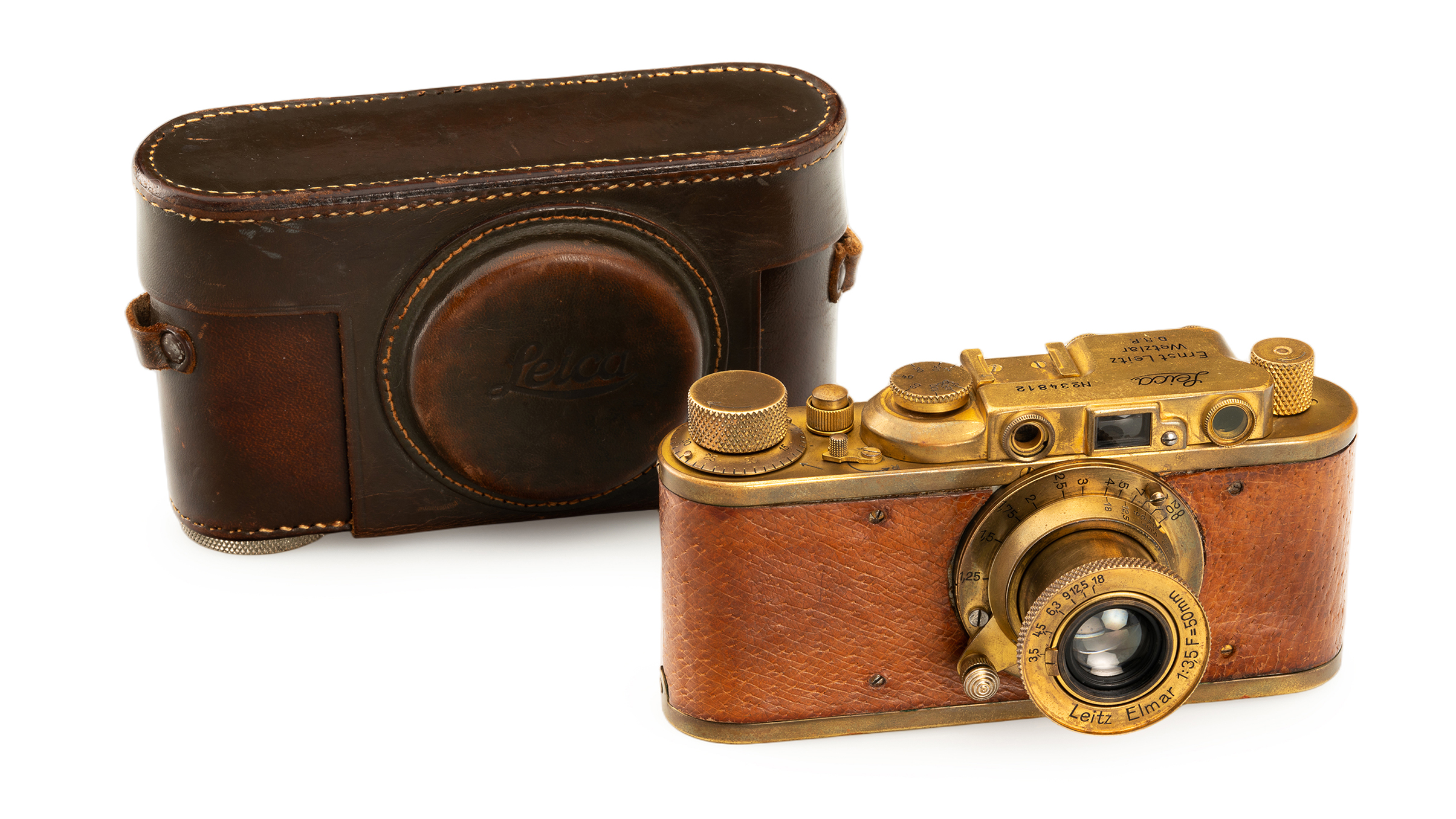 Vintage Leica camera with brass details, leather design, and a protective case, showcasing classic photography craftsmanship