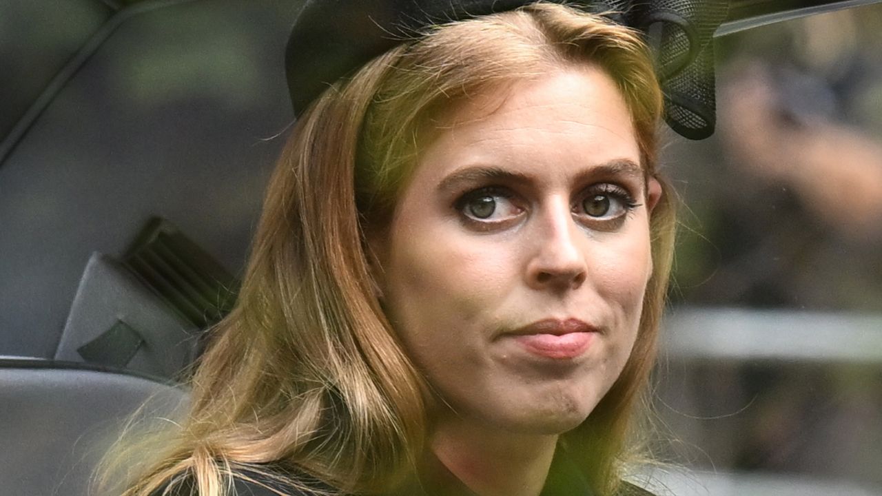 Princess Beatrice wears a black hat with a black coat