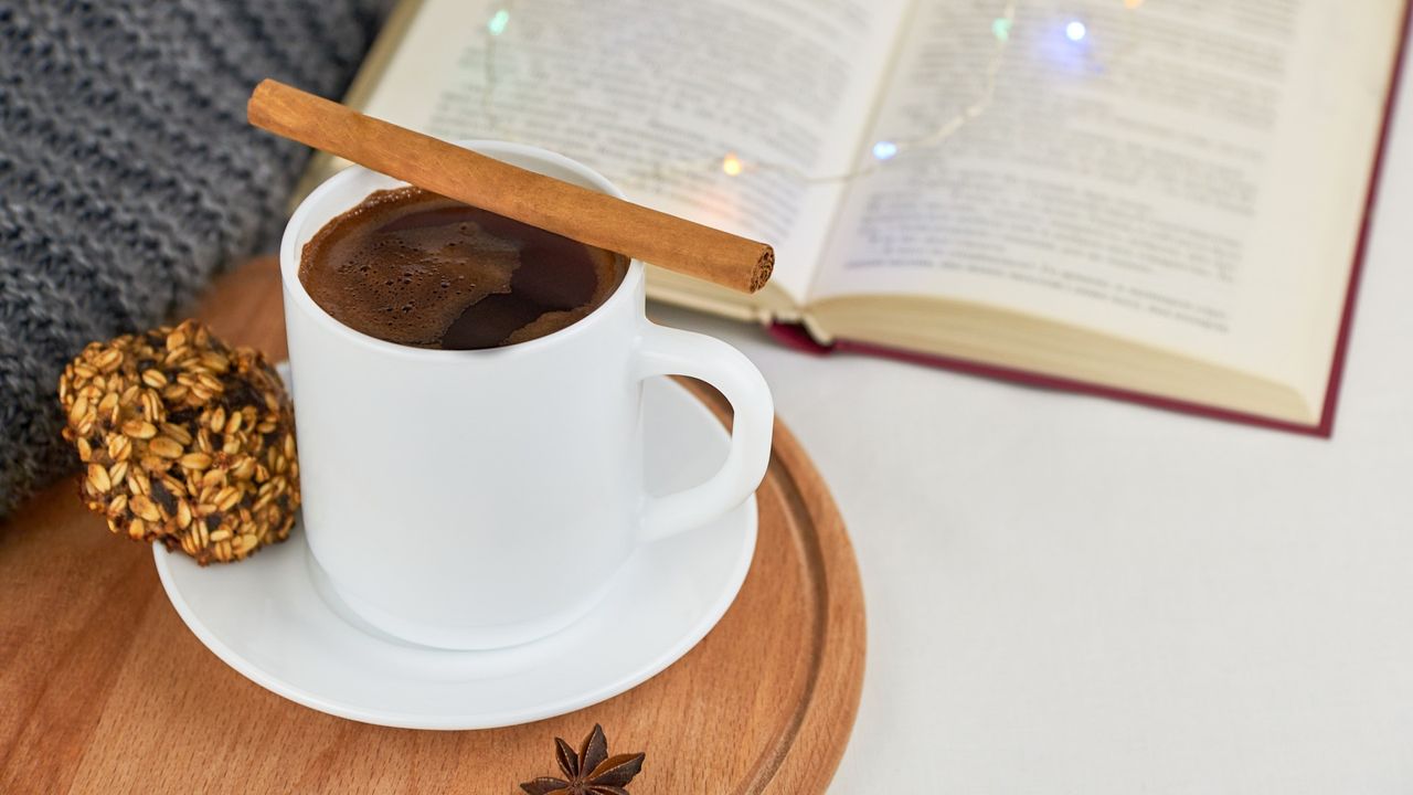 Spiced coffee, oatmeal cookies and book in background