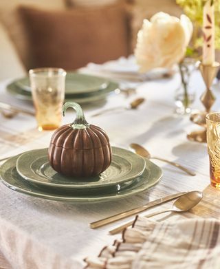 A table setting with a small, pumpkin-shaped bowl