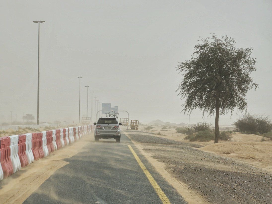 Sand is blown across the road en-route to the start