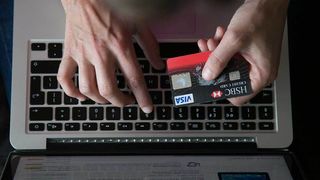 Person using credit card to buy items online using a laptop