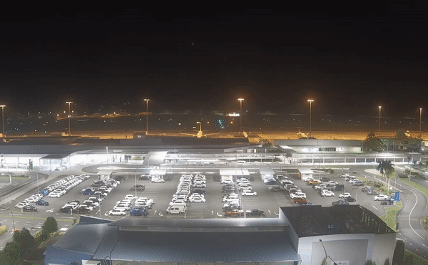 Video footage of a flash lighting up the night sky above an airport runway.
