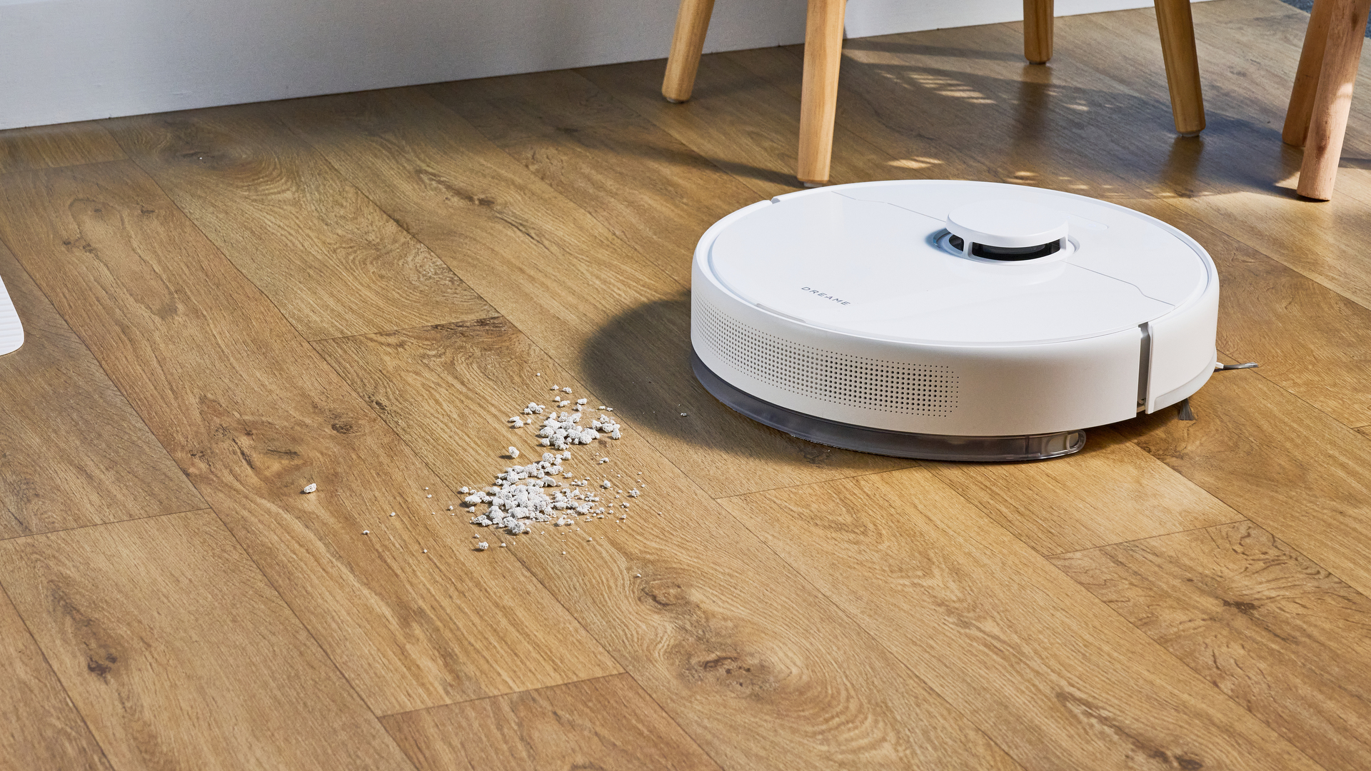 Dreame D10 Plus Gen 2 photographed on a wooden floor in front of a blue backdrop