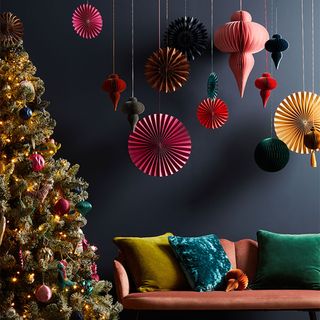 Room with a decorated christmas tree and paper baubles hanging decorations
