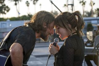 bradley cooper and lady gaga sing on stage at an outdoor concert in A Star is Born