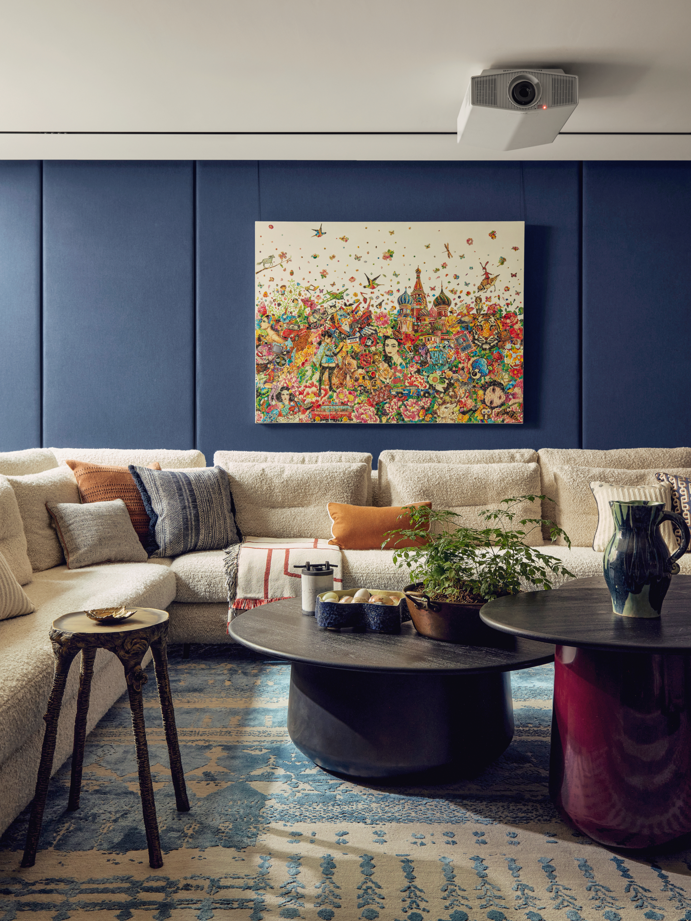 Snug with blue paneled walls, cream corner sofa and nesting black and plum coffee table