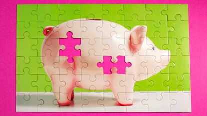 A jigsaw puzzle in the shape of a piggy bank is missing two pieces.