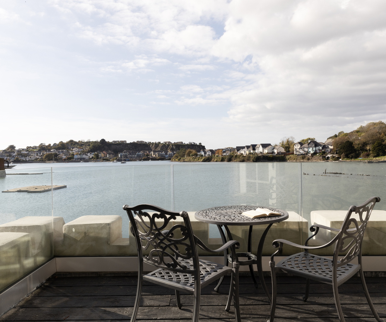 terrace with a table and chairs overlooking the lake