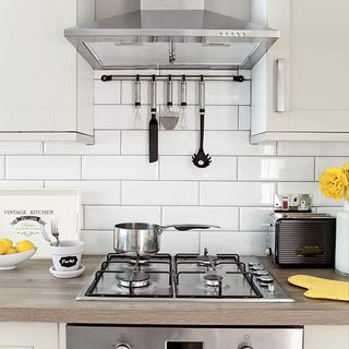 kitchen room with white wall tiles and gas hob with cooker
