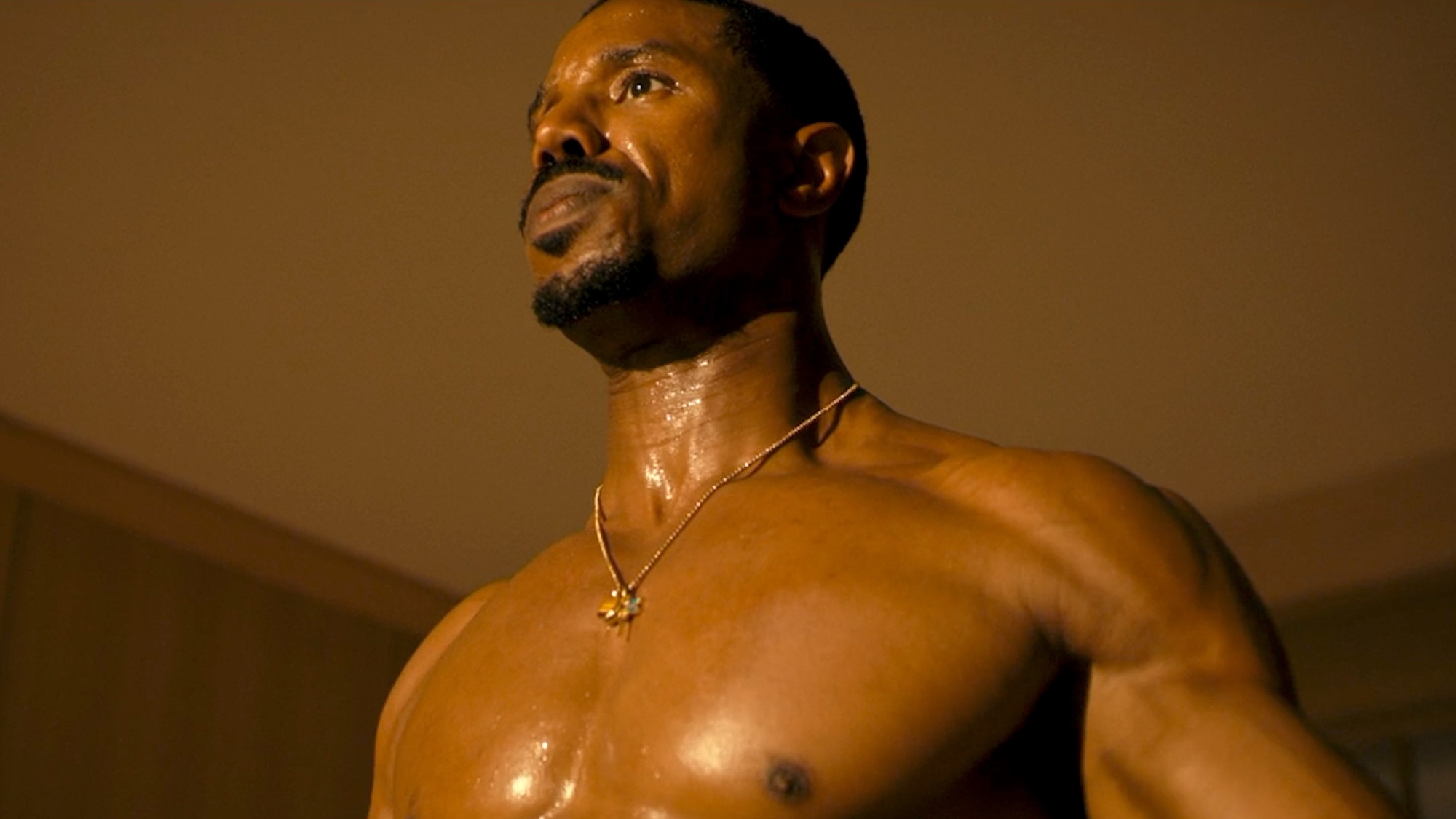 Michael B. Jordan shirtless, looking out into the distance in The Thomas Crown Affair
