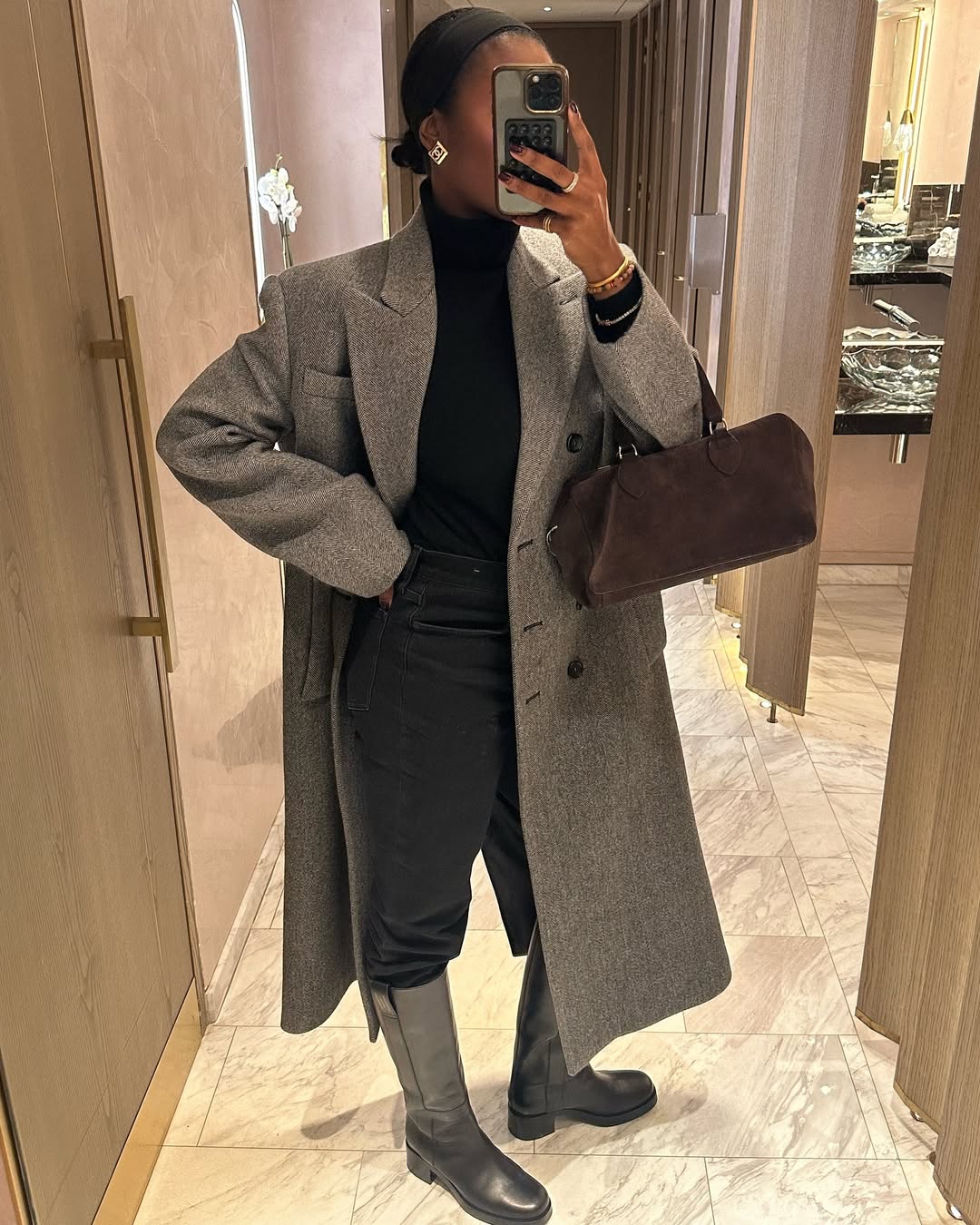 Woman wearing boots tucked into jeans trend fall 2025.