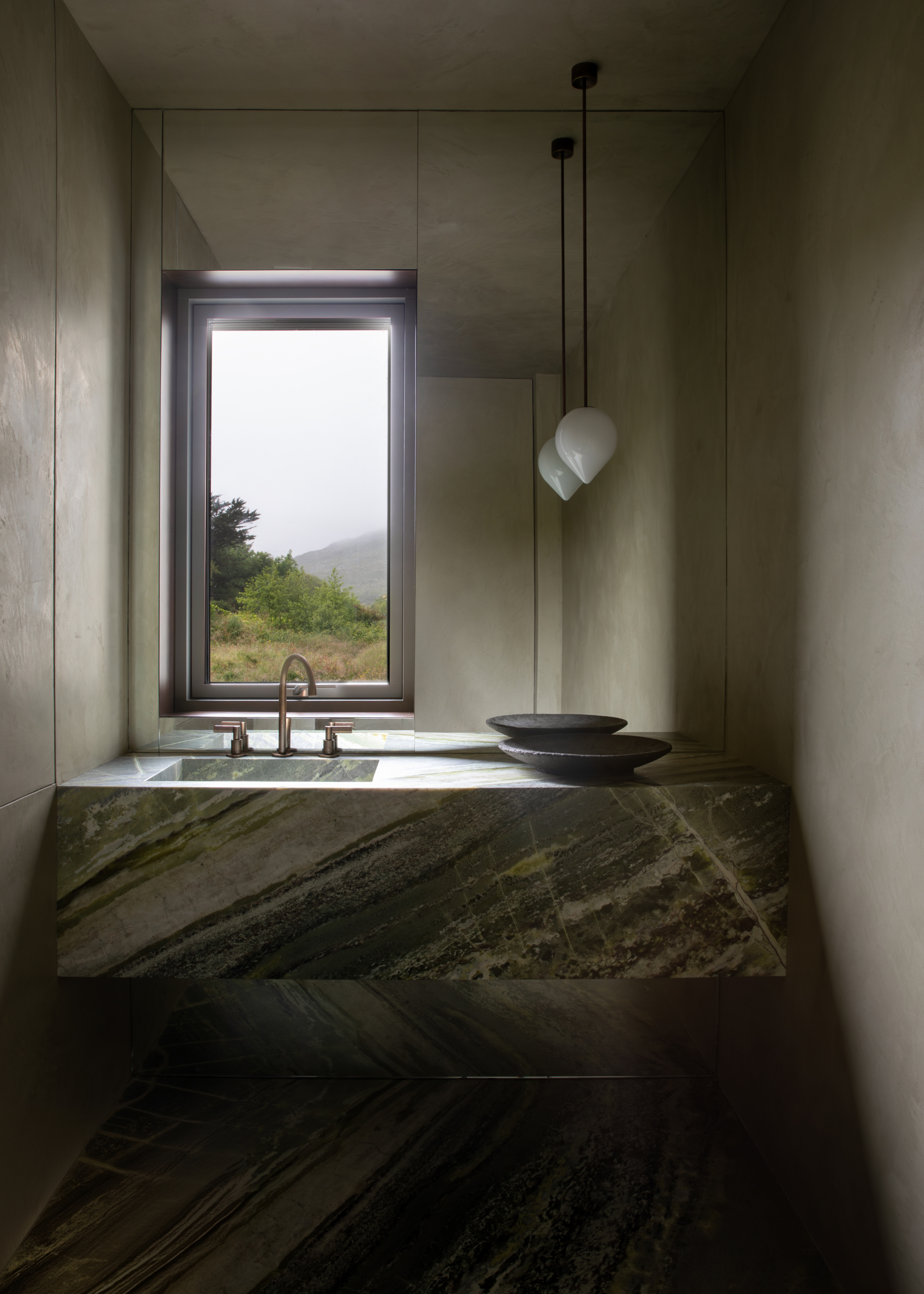 an irish green marble sink in a small powder room overlooking a field