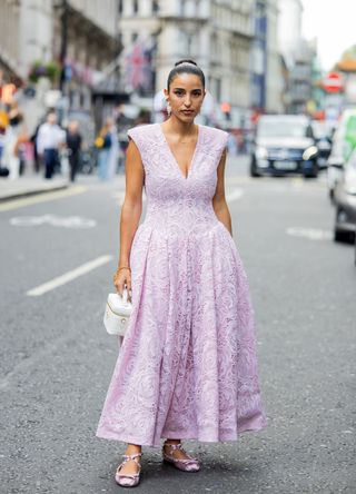 Bettina Looney wears pink sleeveless dress, white bag outside Huishan Zhang during London Fashion Week September 2023