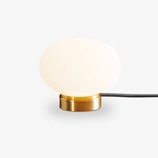 A table lamp in a pebble shape with a brass base