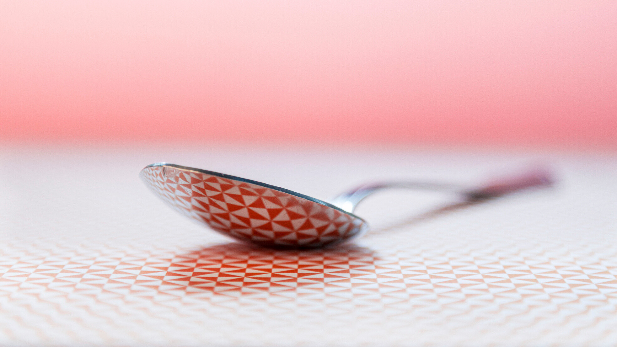 A metal spoon against a colourful background
