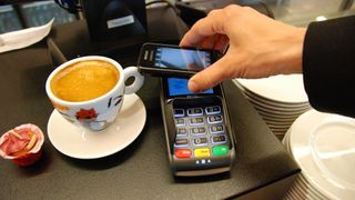 Someone pays for coffee using their phone