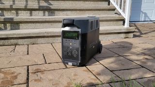 An EcoFlow Delta Pro portable power station sitting on a paved floor in front of some steps