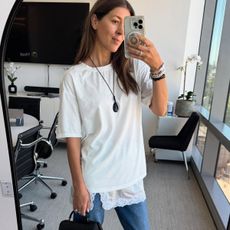 Woman in white tee, lace-trimmed skirt and jeans