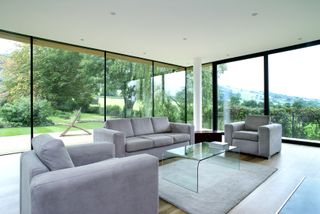 minimalist living room with grey sofa and big windows