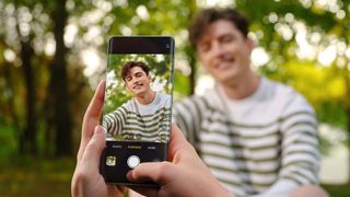The Oppo Reno 11 5G being used to take a portrait photo of a man