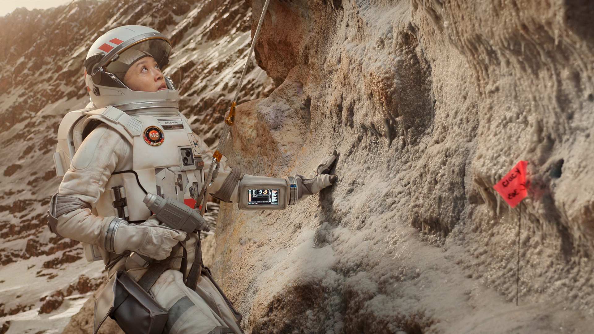 a woman in a spacesuit doing geological tests