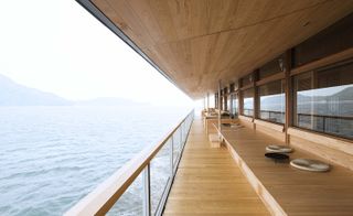 walk way along the side of a boat with wooden benches