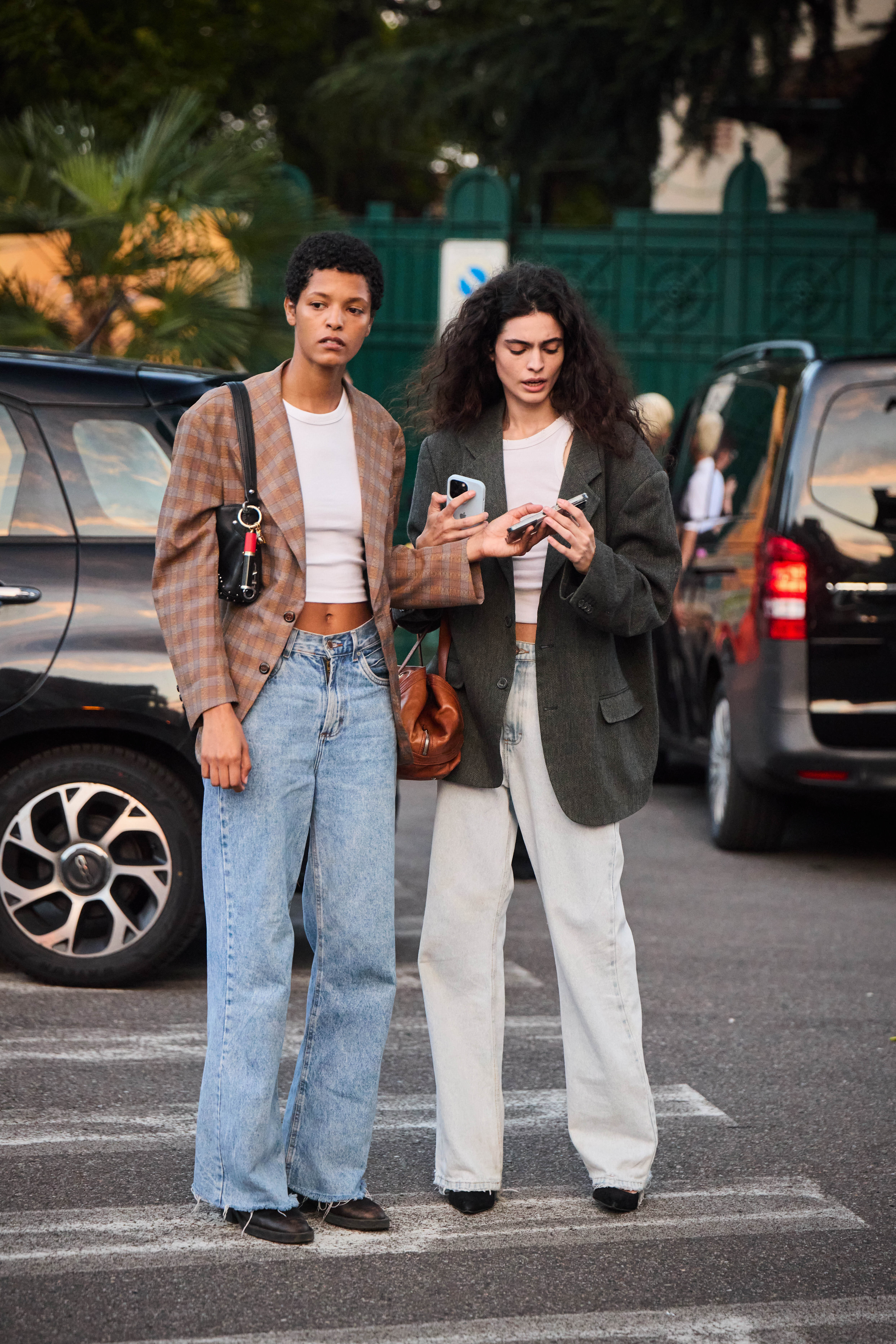 Two people in jeans, boots, white tank, and an oversize blazer.