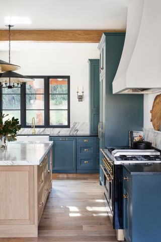 Traditional style kitchen with blue units and wood island