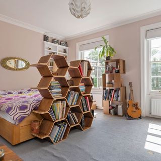 victorian home with quirky octagonal tower bedroom with zoning wall bed and cushions bookcase and mirror
