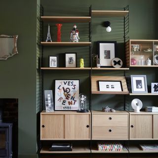 Green living room with industrial shelving and artwork