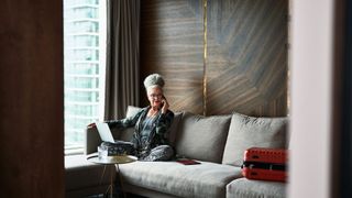 Woman sitting in boutique hotel room on the phone