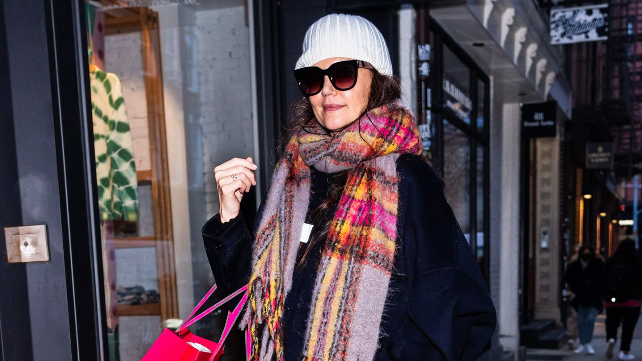 Katie Holmes wearing a colorful scarf with sunglasses and a winter white beanie