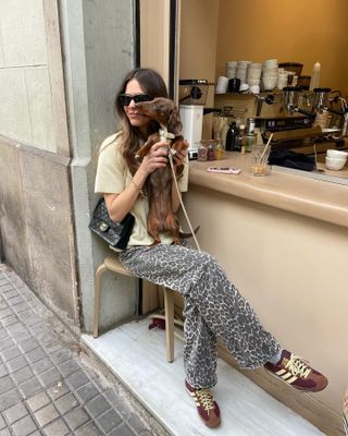 @lunaisabellaa wears a butter yellow t-shirt, leopard print jeans and burgundy Adidas SL 72 sneakers