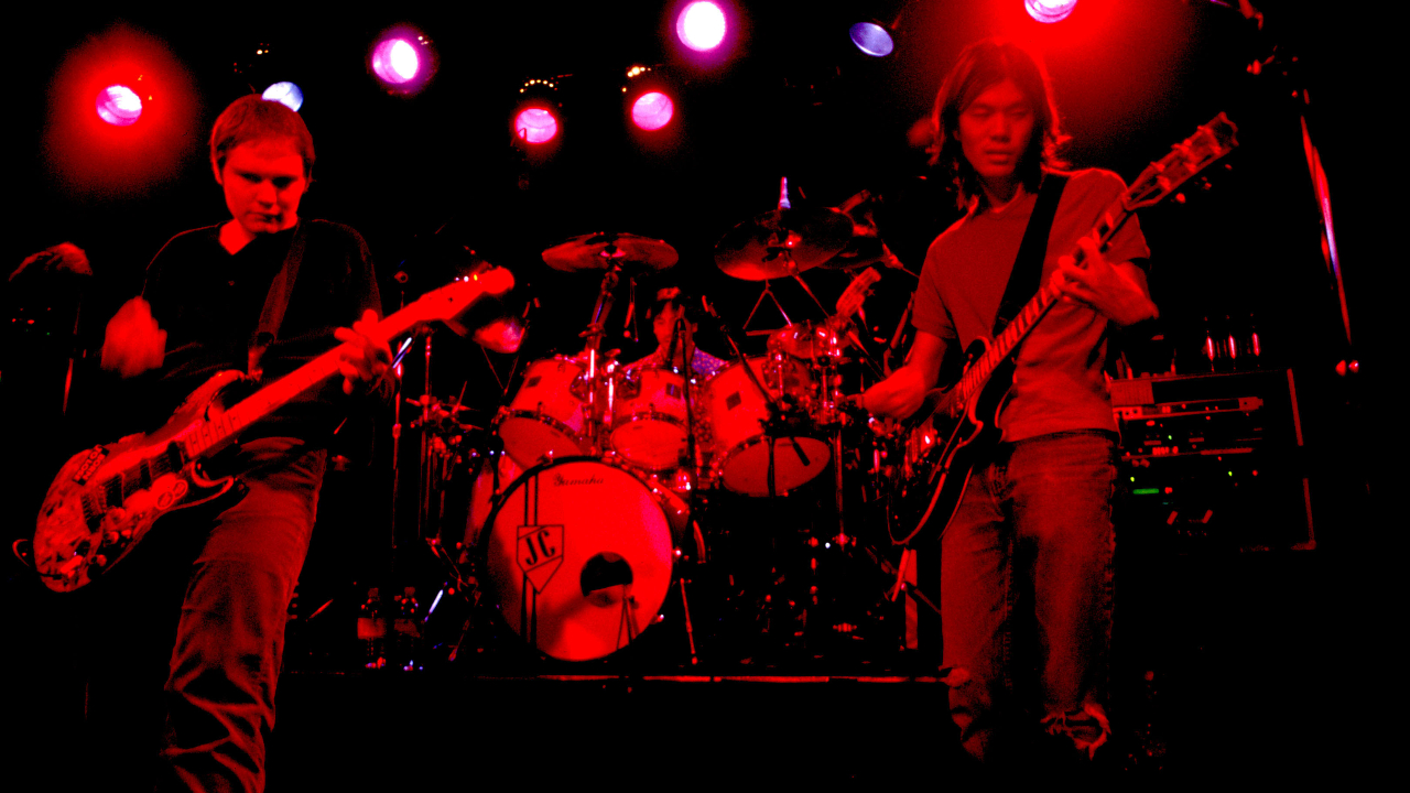 Smashing Pumpkins on stage bathed in red light