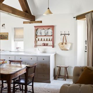 country style kitchen diner with vintage table and chairs, sofa and wall display rack