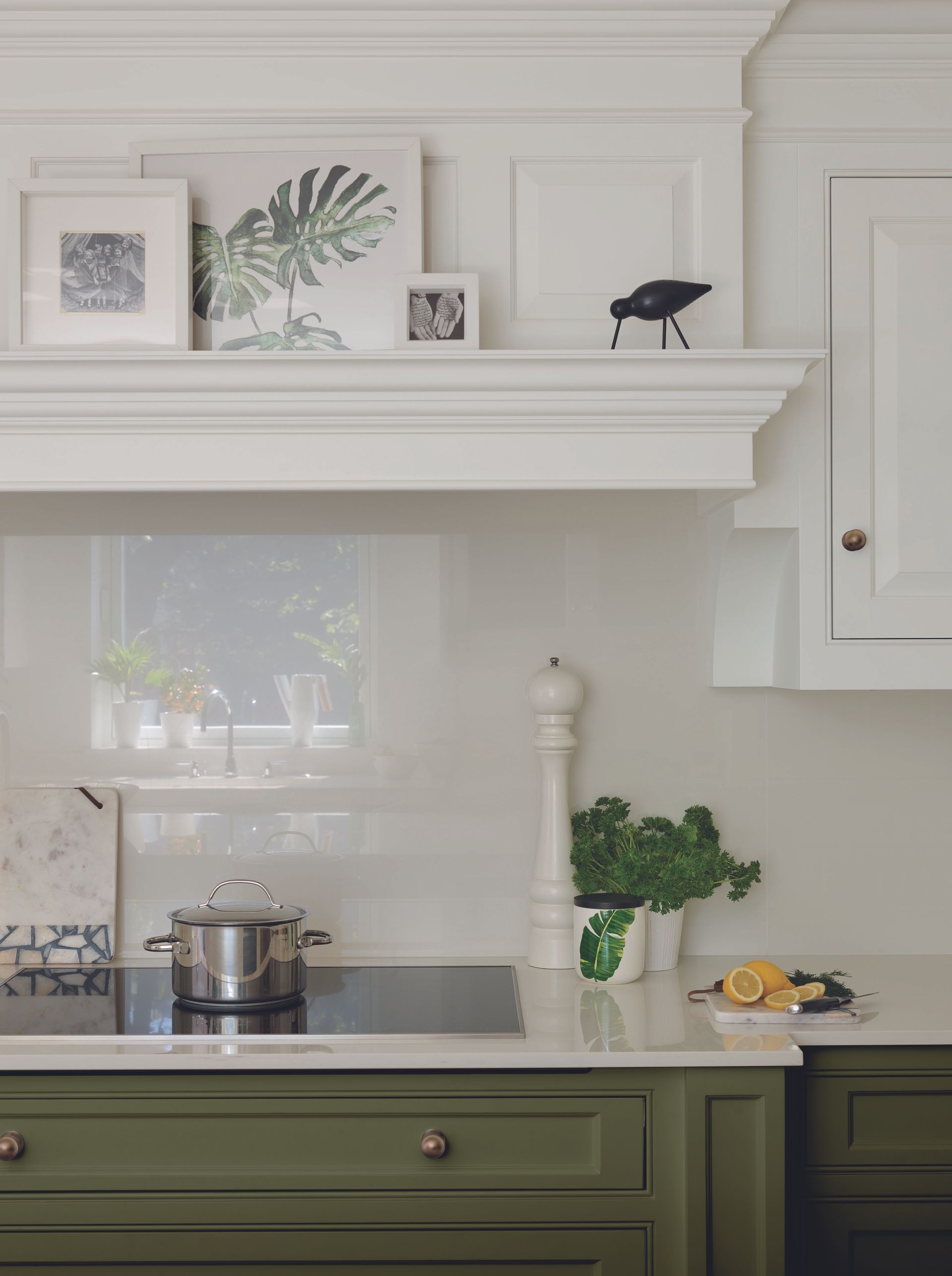 Olive green and white kitchen by Tom Howley with white glass backsplash